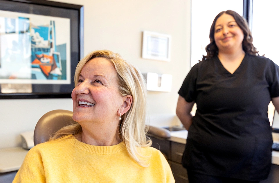 Smiling female patient speaking with a dental team member about cosmetic dentistry options at Dr. Andrew Jackson DDS