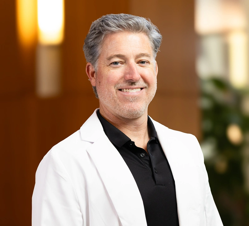 Dr. Andrew Jackson DDS, experienced general dentist in Nashville, TN, smiling in his white coat